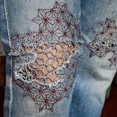 someone is wearing jeans with crochet on them