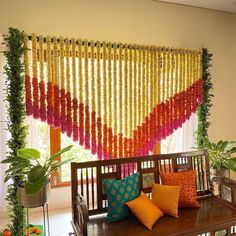 a wooden bench sitting in front of a window covered in flowers and string hanging from the ceiling