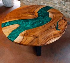 a wooden table with green paint on it and a stone wall in the back ground