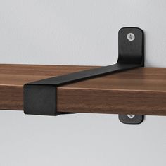 a wooden shelf with metal brackets on it