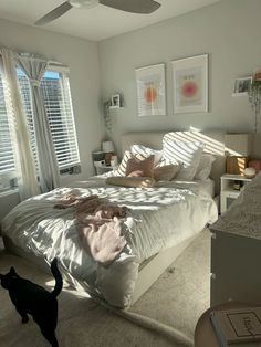 a bedroom with a large bed and a cat on the floor in front of it