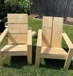 two wooden chairs sitting in the grass