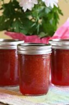 three jars filled with red liquid sitting on top of a table