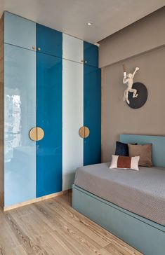 a blue and white bedroom with a bed in the middle, two closets behind it