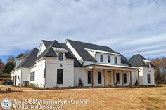 a large white house sitting on top of a dry grass field