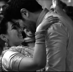 a bride and groom sharing a hug at their wedding reception in black and white photo