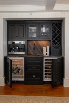 a kitchen with wooden floors and black cabinets