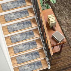 an overhead view of a stair case with rugs on the bottom and side rails