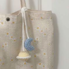 a crocheted blue and white object hanging from a curtain with stars on it