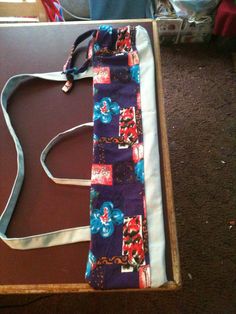 a purple and blue tie sitting on top of a wooden table next to a bag