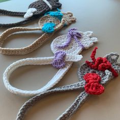 four crocheted scissors are lined up on a table