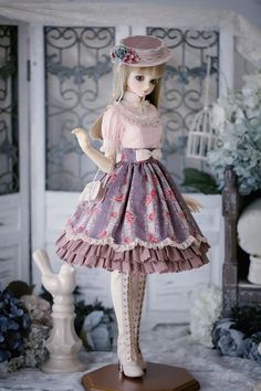 the doll is wearing a dress and hat