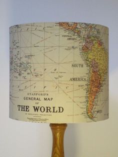 a lamp that is on top of a wooden base and has a map on it