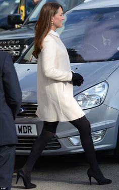 a woman walking down the street in front of cars