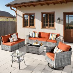 an outdoor patio with wicker furniture and orange cushions