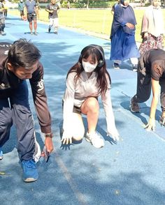 two people wearing face masks are kneeling down