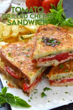 grilled cheese sandwich with tomato and lettuce on white plate next to potato chips