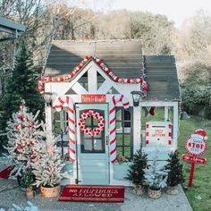 a small white house decorated for christmas with candy cane decorations