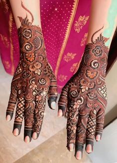 two hands with henna tattoos on them