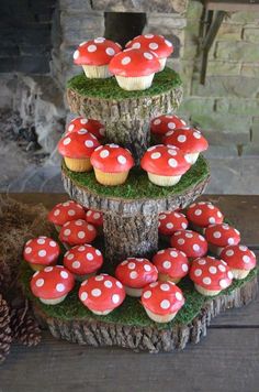 three tiered tree stump with mushrooms on top and pine cones in the bottom for decoration