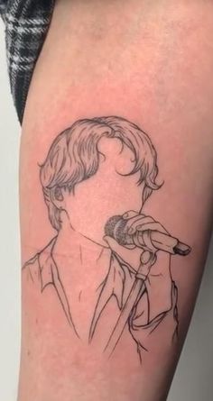 a man with a microphone tattoo on his arm