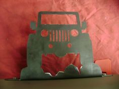 a metal cutout of a jeep on a red background