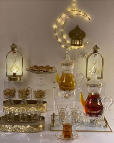 an assortment of tea and sweets displayed on a white tablecloth with gold trimmings