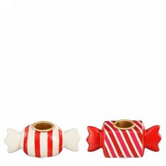 two red and white candy canes sitting next to each other on a white surface