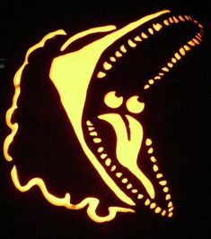 a close up of a carved pumpkin in the dark