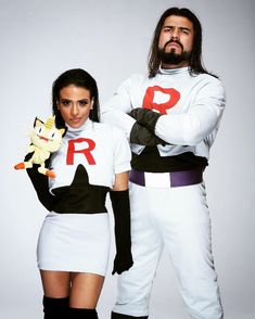 two people dressed in costumes standing next to each other with one holding a stuffed animal