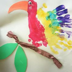 a paper plate with a colorful bird on it's side and a green leaf