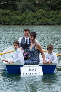 a man and two boys in a boat with just married sign