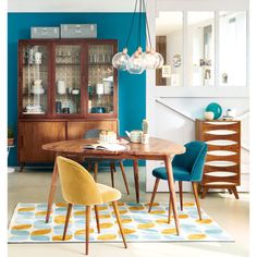 a dining room with blue walls and yellow chairs