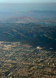 an aerial view of a city with mountains in the background