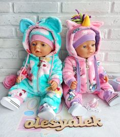 two baby dolls sitting next to each other