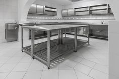 an empty commercial kitchen with stainless steel counters and shelves on the wall, in black and white