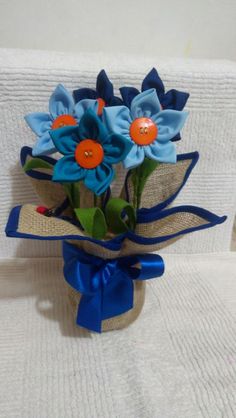 a bouquet of flowers sitting on top of a white chair next to a blue ribbon