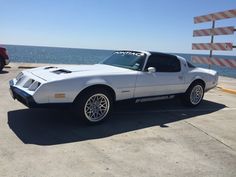 a white car parked next to the ocean