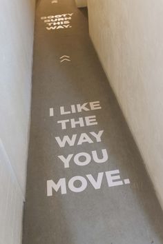 a long hallway with the words i like the way you move painted on the floor