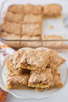 three pieces of peanut butter bars stacked on top of each other in front of a baking dish