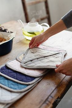 a woman is making quilts on a table with other dishes and utensils