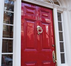 a red front door with white trim on a brick building in washington, d c