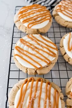 iced cookies with caramel drizzle and white frosting on a cooling rack