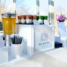 there are many different types of drinks on the counter in front of the store window