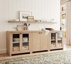 a living room with a rug and shelves filled with dishes on top of it's sides