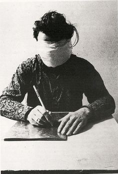 a woman with a bandage on her head sitting at a desk writing in a notebook