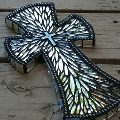 a cross made out of stained glass sitting on top of a wooden bench