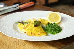 a white plate topped with food on top of a wooden table