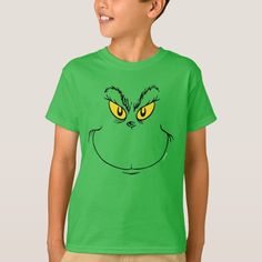 a young boy wearing a green t - shirt with the grin face drawn on it