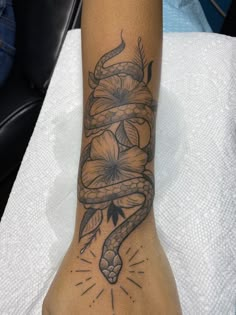 a woman's foot with a snake and flowers on it